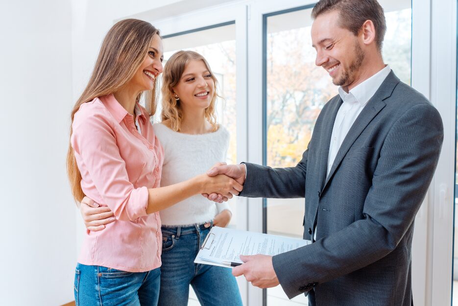 Estate agent handing over documents and greeting new tenants, illustrating compliance expectations for landlords under the Renters’ Rights Act from 27 December 2025.