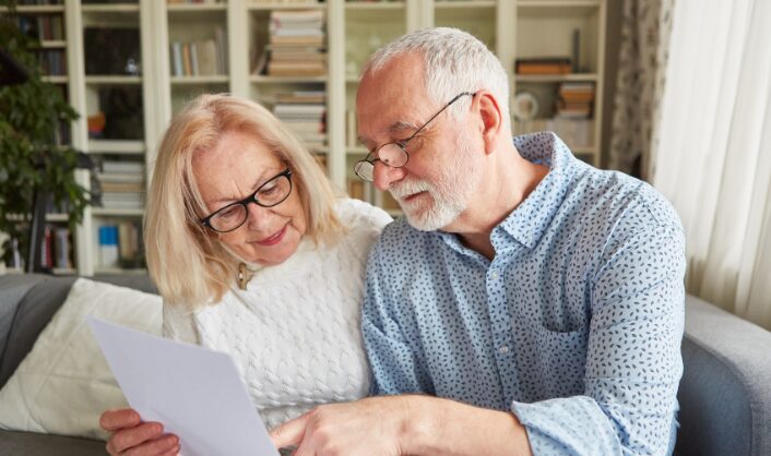 Couple reviewing paperwork before setting a property asking price.