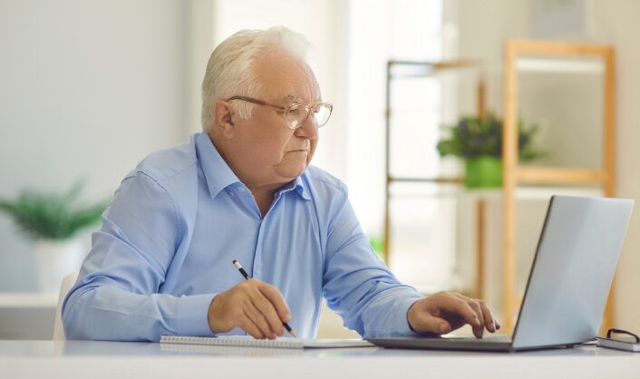 Landlord reviewing tenancy documents and market evidence on a laptop while preparing a compliant once-a-year Section 13 rent increase