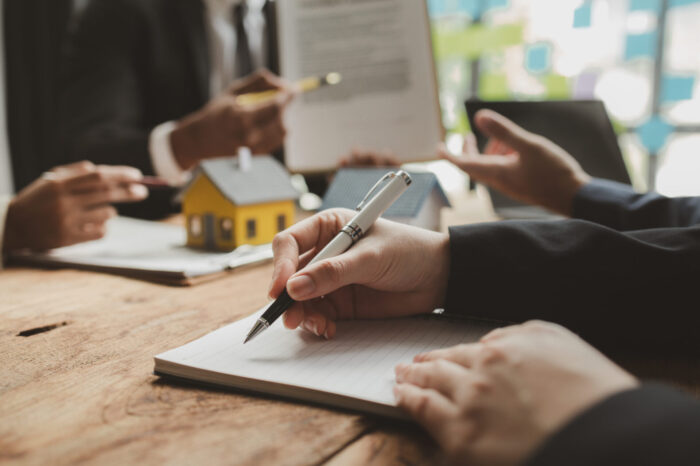 Architects are reviewing plans together, buildings are being evaluated by architects on what type of construction they need to be built, Engineers are designing a structure according to blueprints,