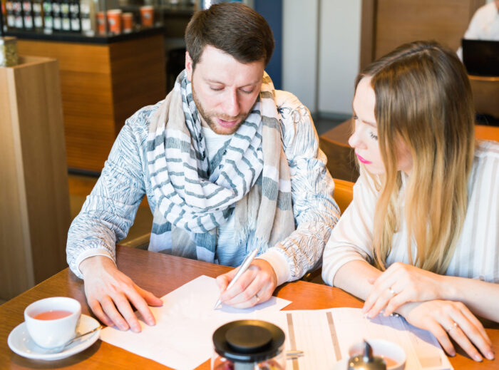 Male and female business colleagues working together on a hard problem at indoors cafe. They have strained expression on their faces